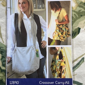 May include: A sewing pattern for a crossover carry-all bag. The pattern is called "Indigo Junction" by Amy Barickman and has the pattern number IJ890. The pattern shows a woman wearing a black vest and a white shirt with a striped scarf. The bag is shown in three different views: a front view, a side view, and a close-up of the pocket.