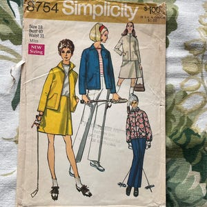 May include: Vintage Simplicity sewing pattern, number 8754, featuring illustrations of women's fashion designs. The pattern includes sizing information: Bust 40 inches, Waist 31 inches, and size 18. The cover has a yellow and white color scheme.