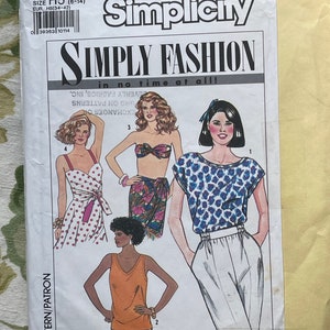 May include: Simplicity sewing pattern number 9627, size H5 (6-14), for a sleeveless top, a wrap skirt, a halter top, and a blouse with a polka dot pattern. The pattern is titled "Simply Fashion in no time at all!"