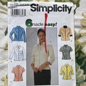 May include: A Simplicity sewing pattern packet featuring illustrations of six different shirt styles. The packet includes the text "6 made easy!" and size information. The color palette includes blue, yellow, and peach.