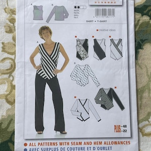 May include: Burda sewing pattern 8217 for a shirt or t-shirt. The pattern includes instructions for sizes 10-22 and 36-48. The pattern includes a black and white striped shirt with a wrap design, a black and white polka dot shirt with a wrap design, and a black and white striped shirt with a wrap design.