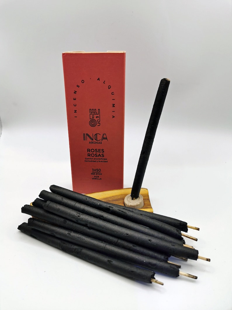 Puede incluir: Una caja de inciensos negros con una etiqueta roja que dice "INCA AROMAS ROSES ROSAS Comfort and Freshness Comodidad y Frescura 1H50 PER STICK POR VARILLA".