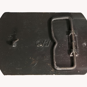 May include: A black leather belt buckle with a silver metal buckle and the letters "OJ" engraved on the front.