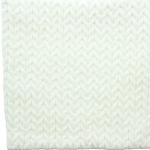 May include: White knitted throw blanket with a cable knit pattern.