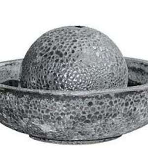 May include: A gray stone water fountain with a textured, spherical top and a wide, shallow bowl base. The fountain is designed for outdoor use and has a simple, modern aesthetic. The surface has a speckled pattern.