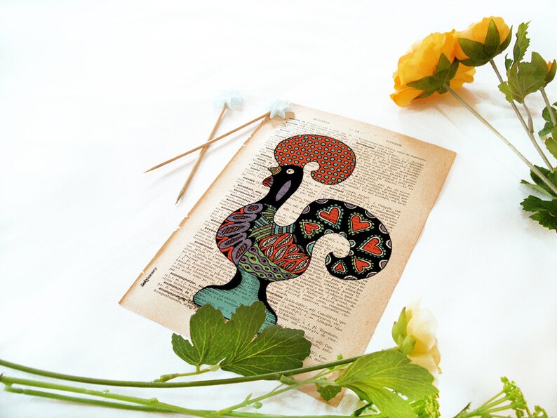 Peut inclure: Une illustration color&eacute;e de coq dessin&eacute;e sur une page de livre vintage. Le coq est noir, vert, rouge, orange et violet. Le coq est entour&eacute; de fleurs blanches et de feuilles vertes.
