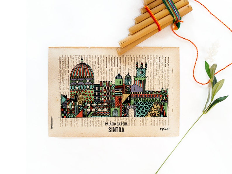 May include: A colorful illustration of the Palacio da Pena in Sintra, Portugal, printed on a vintage book page. The illustration is in a geometric style and features a variety of colors, including green, blue, red, and yellow.