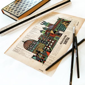 May include: A colorful illustration of the Palacio da Pena in Sintra, Portugal, printed on a vintage book page. The illustration is surrounded by text and is accompanied by three paintbrushes.