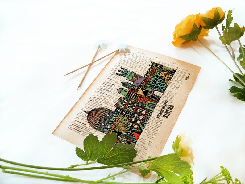 May include: A vintage book page with a colorful illustration of the Palacio da Pena in Sintra, Portugal. The illustration is surrounded by text in Portuguese.