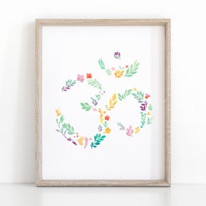 May include: A framed print of a floral Om symbol in shades of green, yellow, pink, and purple. The Om symbol is a spiritual symbol in Hinduism and Buddhism.