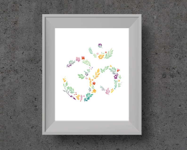 May include: A white framed print with a floral design of the Om symbol in shades of green, yellow, orange, pink, and purple.