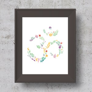 May include: A framed print of a floral Om symbol in shades of green, yellow, pink, and purple. The Om symbol is made up of stylized flowers and leaves.