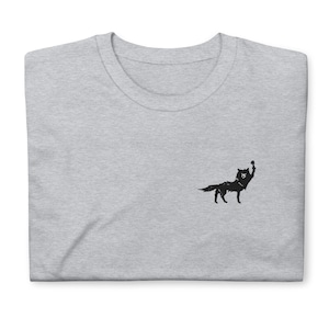 Pode incluir: Uma camiseta cinza mescla com uma silhueta preta de um lobo com a pata levantada.
