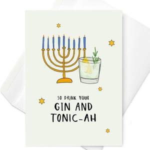 May include: Greeting card with a light green background, a gold menorah with blue candles, and a gin and tonic illustration. The text "SO DRINK YOUR GIN AND TONIC-AH" is written in black. Yellow stars are scattered around the card.
