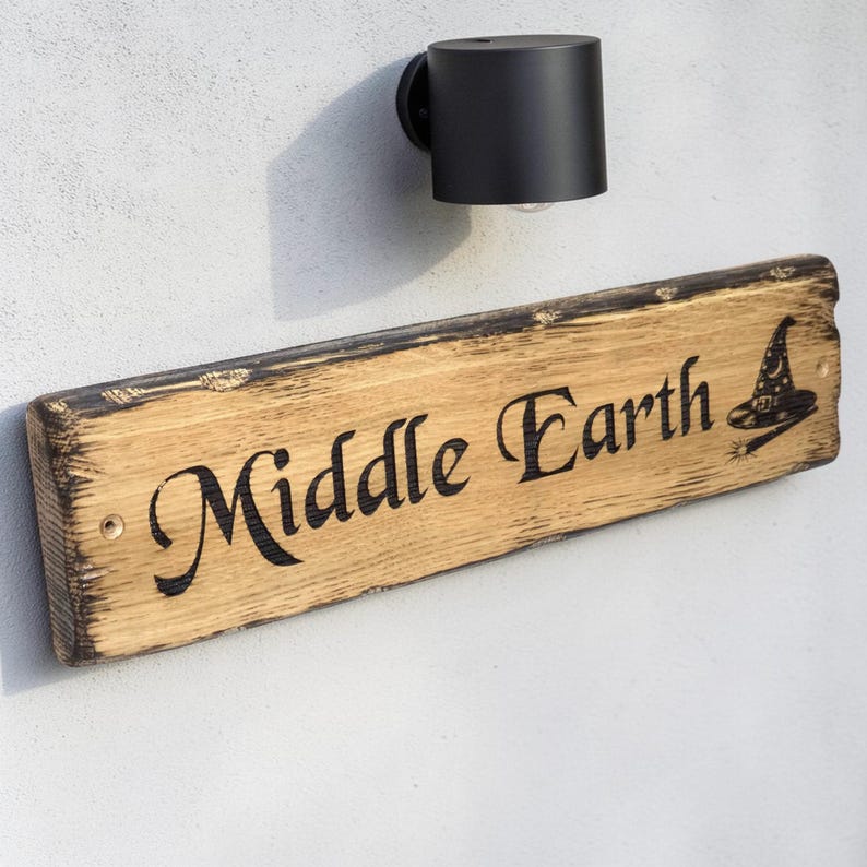 Rustic oak house sign mounted below outdoor wall light