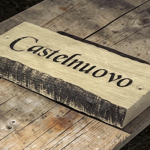 Handcrafted oak house name sign displayed on rustic wooden table lifestyle photography UK