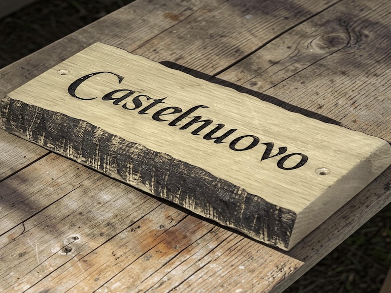 Handcrafted oak house name sign displayed on rustic wooden table lifestyle photography UK