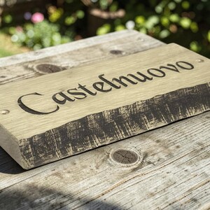Handcrafted oak house name sign displayed on rustic wooden table lifestyle photography UK