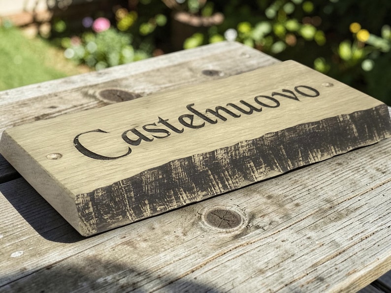 Handcrafted oak house name sign displayed on rustic wooden table lifestyle photography UK