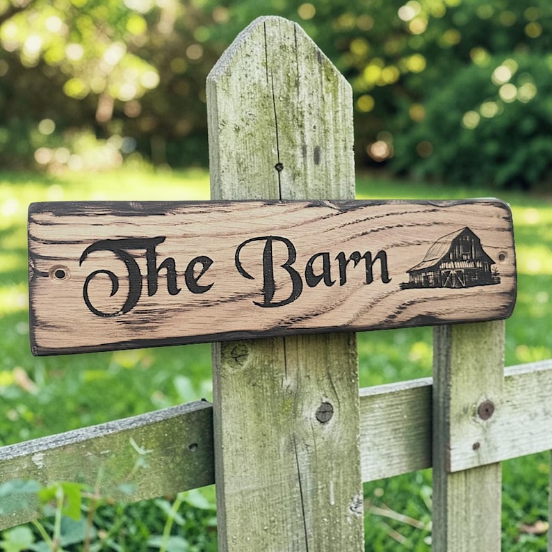 Engraved barn style oak house sign mounted on garden fence