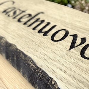 Deep engraved solid oak house sign close up showing natural wood grain detail
