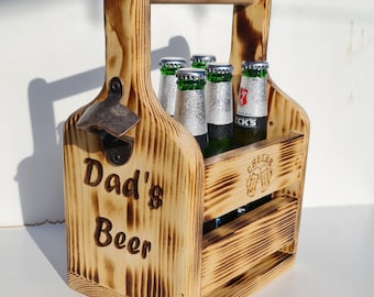 May include: A wooden six-pack beer carrier with a built-in bottle opener. The carrier is personalized with the text "Dad's Beer".