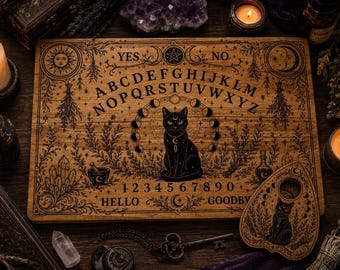 May include: A rectangular wooden spirit board featuring a central black cat illustration, the alphabet, numbers zero through nine, and the words YES, NO, HELLO, and GOODBYE. The board includes moon phase graphics, botanical motifs, and a matching wooden planchette.