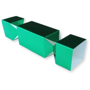 Puede incluir: Un cracker navideño metálico verde con interior blanco. El cracker está doblado y listo para ser tirado.