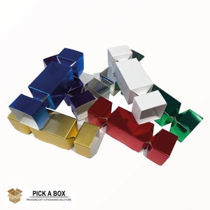 May include: Assortment of colorful metallic Christmas cracker boxes. The boxes are made of cardboard and have a shiny, metallic finish. The colors include red, green, blue, gold, silver, and white.