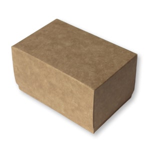 Puede incluir: Una caja de cartón marrón de forma rectangular. La caja está hecha de un material texturizado y tiene una superficie ligeramente rugosa.