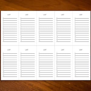 May include: A white paper with multiple sections, each labeled "LIST" at the top. Each section contains numbered lines for writing. The paper is on a dark wooden surface.