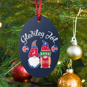May include: A blue and white Christmas ornament with two gnomes wearing red and white hats. The ornament has the text "Gle&eth;ileg J&oacute;l" written on it.