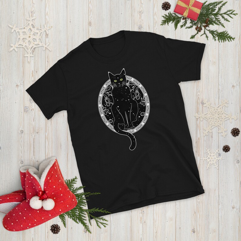 May include: Black t-shirt with a white graphic of a black cat sitting inside a circle with stars and the words "Nightfall" and "Lunar" around the circle.