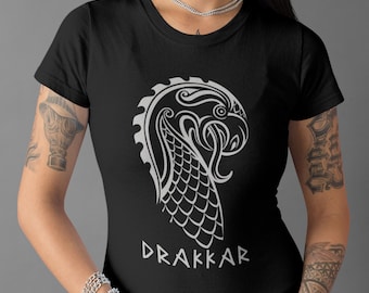 May include: Black t-shirt with a white graphic of a stylized dragon head and the word "DRAKKAR" underneath.