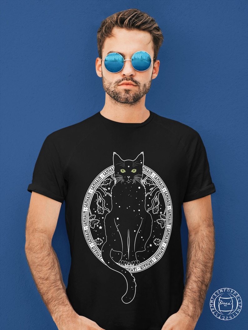 May include: Black t-shirt with a white graphic of a black cat with green eyes sitting in a circle of stars and the text "SAMHAIN" repeated around the circle.
