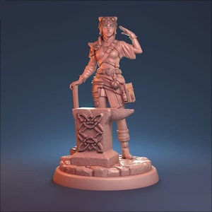 May include: A miniature figurine of a female character wearing goggles and a leather outfit, standing on an anvil with a Celtic knot design. The figurine is painted in a light brown color.