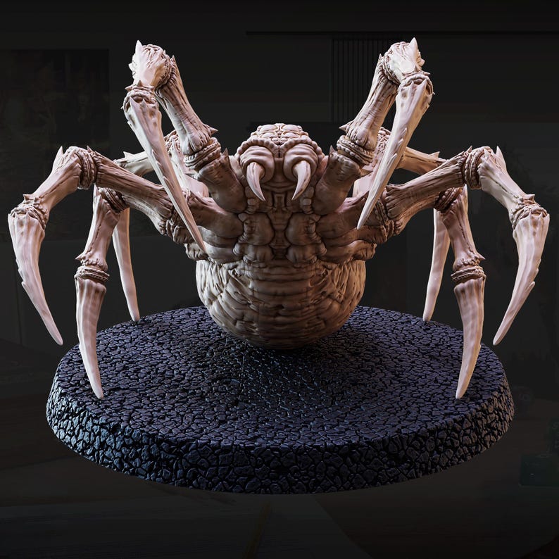 May include: A detailed, beige-colored spider figurine with multiple legs and large pincers. The spider is posed on a textured, black circular base. The figurine has a detailed, textured body and is likely a collectible or decorative item.