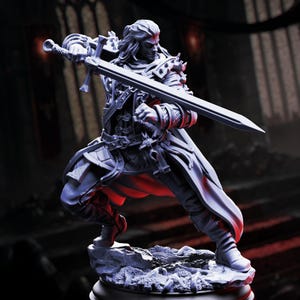 May include: A detailed figurine of a warrior in a dynamic pose, wielding a large sword. The figure is clad in ornate armor and flowing robes, with long hair and a determined expression. The color palette is primarily shades of gray and white, with red accents.