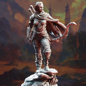 May include: A detailed figurine of a female archer, clad in ornate armor and a flowing cape. She stands on a rocky outcrop, bow drawn, with two arrows and a quiver on her back. The figure is rendered in a neutral color palette, with a blurred background.