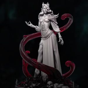 May include: A white figurine of a female elf wearing a flowing gown and a crown. She is holding a staff and has a flowing red cape. The figurine is set against a dark background.