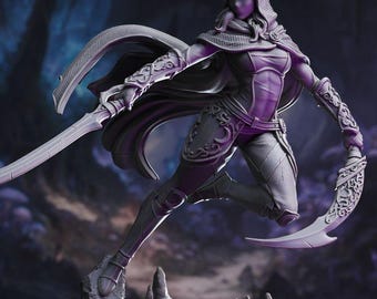 May include: A detailed, gray figurine of a female warrior in a dynamic pose, holding two curved blades. She wears a hooded cloak and armor with intricate designs. The figure is posed on a rocky base, suggesting a fantasy theme.