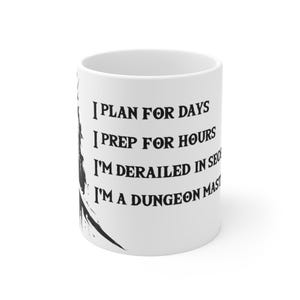 May include: White ceramic mug with black text that reads "I plan for days, I prep for hours, I'm derailed in seconds, I'm a dungeon master."