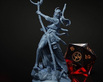 May include: A detailed, blue-gray figurine of a fantasy character holding a staff with a crescent moon on top. The character stands on a rocky base with reaching hands. A large, black, 20-sided die with gold numbers is next to the figurine.