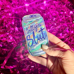 May include: A silver can with a holographic finish and the text "Settlers Blut" in blue lettering.