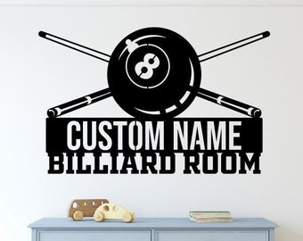 Puede incluir: Calcomanía de vinilo en blanco y negro con una bola de billar y tacos de billar cruzados. La calcomanía dice "CUSTOM NAME BILLIARD ROOM".