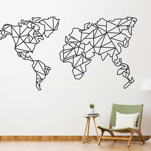 May include: Black geometric world map wall art. The map is divided into triangular shapes, creating a modern, abstract design. The artwork is mounted on a white wall, with a chair and side table in the background.