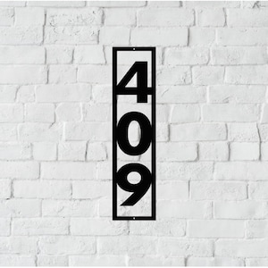 May include: Black metal house number sign with the numbers 409 displayed vertically in a rectangular frame.