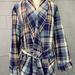 May include: A blue, white, and orange plaid robe with a shawl collar and a matching belt. The robe is displayed on a mannequin and has two front pockets. The fabric appears to be a soft, woven material.