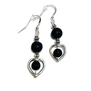 May include: A pair of silver dangle earrings with black lava rock beads and silver heart charms.