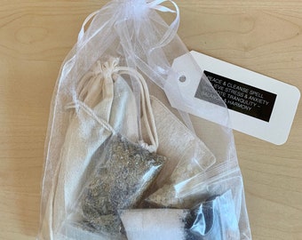 May include: A white organza bag filled with small white pouches containing herbs and crystals. A white tag with black text reads "Peace & Cleanse Spell - Relieve Stress & Anxiety - Promote Tranquility - Balance & Harmony".